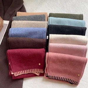 Soft wool blend knit scarf in multiple colors with metallic logo and textured finish