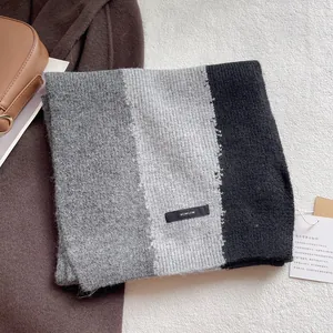 Three-color block knit scarf in dark grey, light grey and black with soft ribbed texture