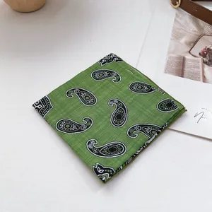Detail eines grünen Baumwoll-Bandanas mit Paisley-Muster und hochwertiger Textur