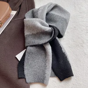 Detail of color-block knit scarf with ribbed texture on a soft plush background