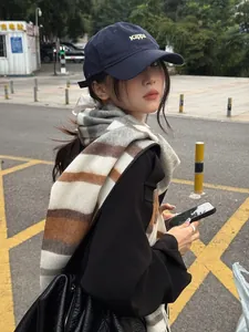 Close-up of blue striped wool scarf paired with a casual autumn winter streetwear outfit