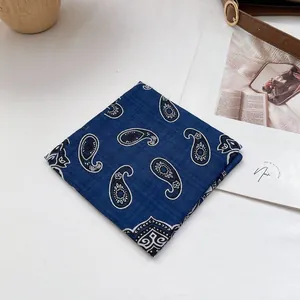 Detail eines dunkelblauen Baumwoll-Leinen-Bandanas mit weißem Paisley-Muster und Nähten