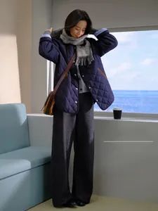 Détail d'une écharpe en laine à carreaux gris avec veste matelassée pour un look rétro