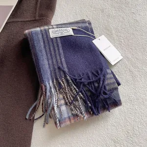 Detail of vintage blue check wool scarf with long tassels and premium woven brand label