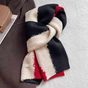 Close-up of thick knitted scarf showing tricolor patchwork texture and brand label