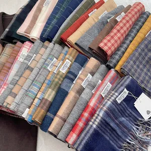 Vue détaillée d'écharpes en laine à 50,2% avec des motifs à carreaux et des franges