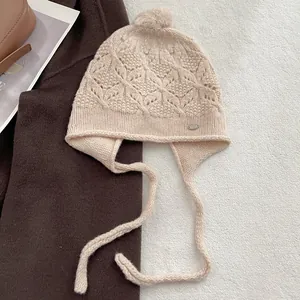 Handmade wool knit trapper hat in beige with ear flaps and decorative floral patterns