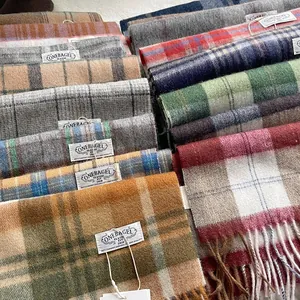 Détail de plusieurs écharpes en laine à carreaux colorés avec franges et étiquettes