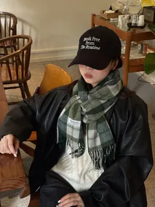 Vista de detalle de bufanda de lana a cuadros de estilo inglés y gorra con bordado