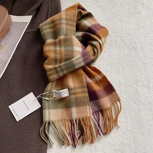 Detail of earthy plaid wool scarf with long tassels and branded woven label