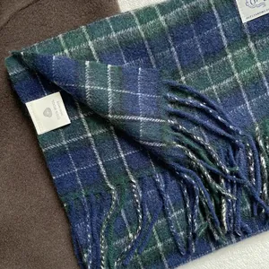 Detail of blue and white plaid 100% pure wool scarf with handmade soft fringe finish