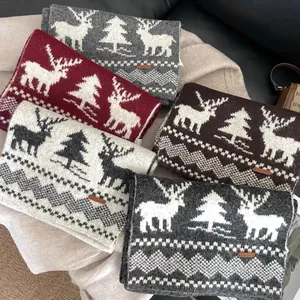 Detail of Christmas knitted wool scarves showing elk patterns and premium leather label