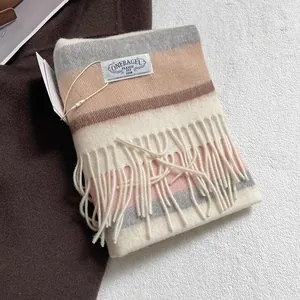 Detail of multi-color striped wool scarf with fringe and a sewn fabric brand label