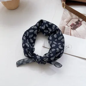 Detailansicht des dunkelblauen Baumwolltuchs mit weißem Blumendruck und Knotendesign