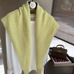 Elegant light green knitted shawl over a white shirt with camellia flower detail