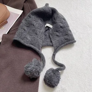 Detail of 100% wool label on dark grey knit beanie with textured check pattern