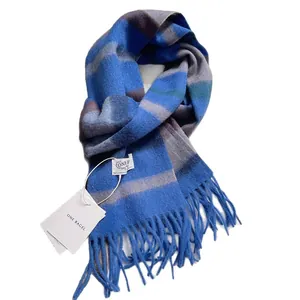 Soft blue striped wool scarf with fringe and brand tag on clean white background