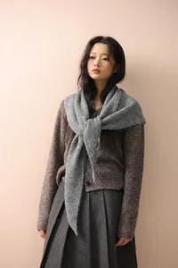 Detail of grey mohair knit shawl over a tweed cardigan and charcoal pleated skirt