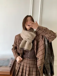 Cozy wool blend scarf styled with a brown plaid blazer and knit sweater outfit