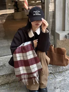 Detalle de bufanda de lana a cuadros rojos y grises con chaqueta de cuello de borrego