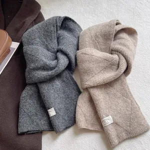 Nahaufnahme weicher Strickschals aus Wolle in Dunkelgrau und Beige mit Webstruktur