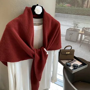 Detail view of red 100% wool knit scarf layered over white shirt on luxury hanger