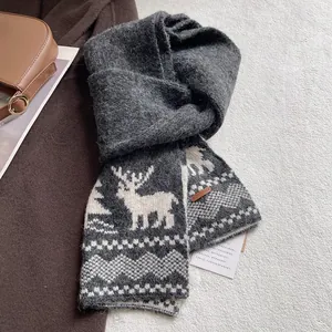 Macro detail of thick knitted winter scarf featuring Nordic elk patterns and leather tag
