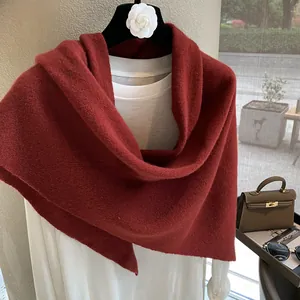 Close-up of deep red knitted wool triangle scarf showing soft premium texture