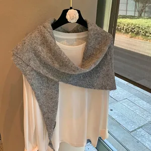 Close-up of grey knitted shawl with soft texture and clean stitching details