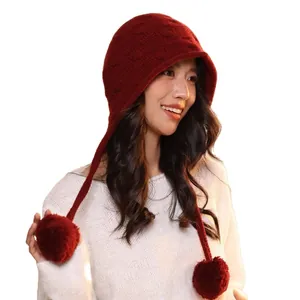 Women's red wool knit trapper hat with warm ear flaps and large pom-pom details