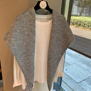 Detail of grey knitted shawl showing plush wool texture and delicate Korea fabric label