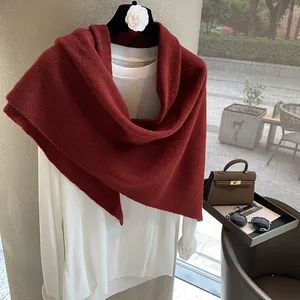 Detail view of burgundy 100% wool triangle scarf with fine knit texture and accessories