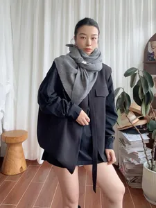 Detail showing the thick 100% wool material and the soft grey texture of the triangle scarf