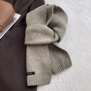Detail of 100% wool knitted scarf with woven label and premium ribbed texture