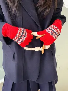 Details roter Fair-Isle-Strickhandschuhe mit geometrischen Mustern und Rippbündchen