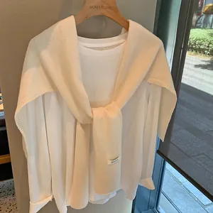 Detalle del chal de punto de 100% pura lana con etiqueta de material y textura suave