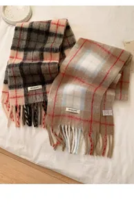 Close-up of thick plaid wool blend scarves with long tassels and soft mohair texture