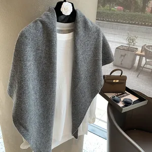 Detailed knit texture of grey 100% wool triangle scarf with white long sleeve top