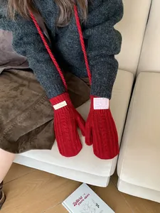 Detail of red cable knit mittens with hanging string and vintage brand woven label