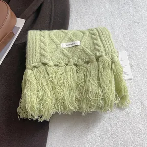 Close-up of mint green 100% wool cable knit scarf with tassel fringe details
