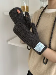 Close-up of dark grey knitted gloves showing wool texture and neck strap detail