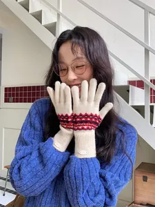 Detail von Fair-Isle-Strickhandschuhen mit Rippbündchen und Marken-Lederaufnäher im Fokus