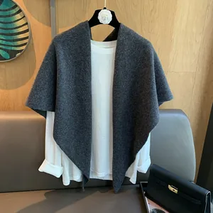 Dark gray knitted 100% wool triangle shawl wrap draped over a white long sleeve shirt