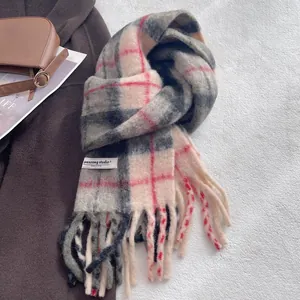 Close-up of wool blend plaid scarf featuring soft fringe and woven brand label