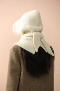Detail of soft cream knitted balaclava hood with ribbed edges worn over a tweed winter coat