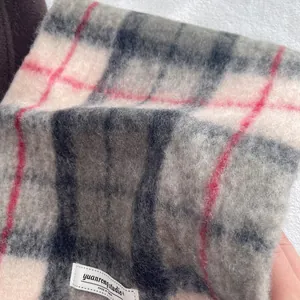 Close-up of fluffy plaid wool scarf showing soft texture and woven brand patch label