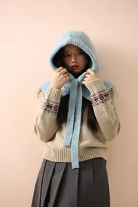 Gros plan de la cagoule en laine bleu clair avec texture tricotée et cordon de serrage