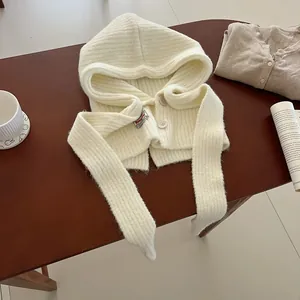 Detail of cream knit balaclava scarf with thick ribbed texture and wooden button closure