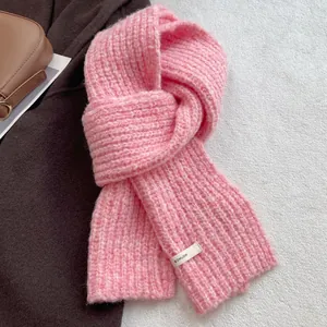 Close-up of pink wool blend chunky knit scarf with ribbed texture and BOWLOW label