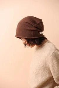 Dettaglio dell'etichetta 100% cashmere su un berretto in maglia marrone di alta qualità